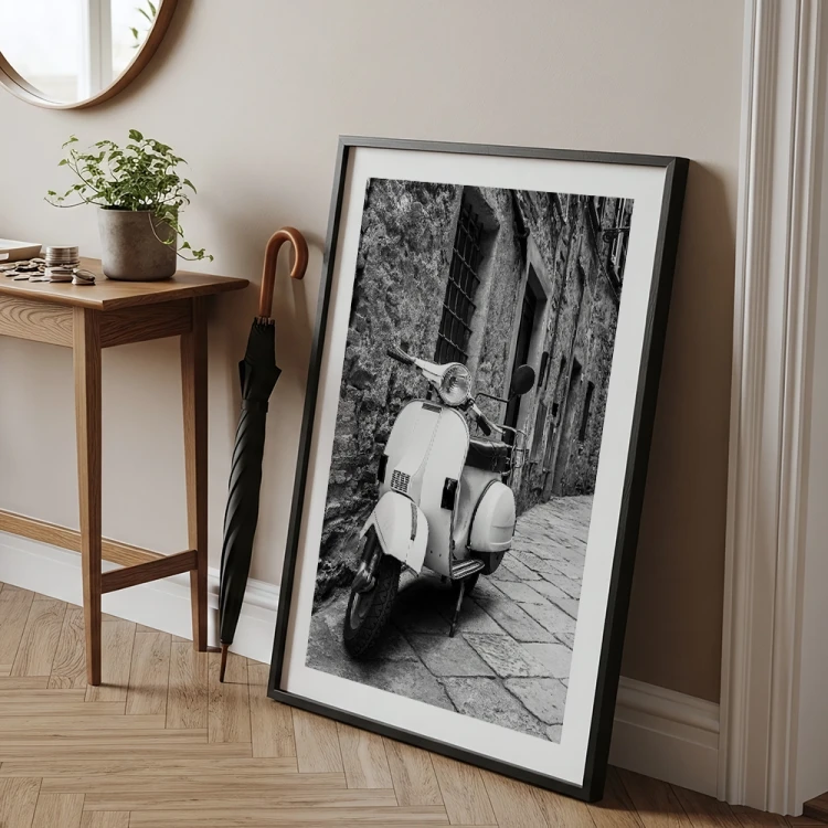 plakat stara vespa z białym obramowaniem w czarnej ramie w przedpokoju