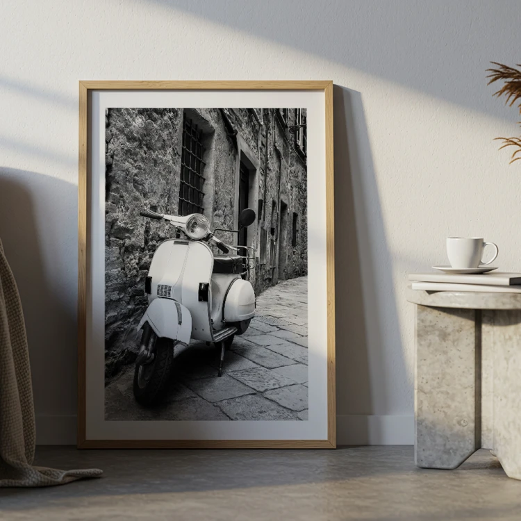 plakat stara vespa z białym obramowaniem w drewnianej ramie w salonie