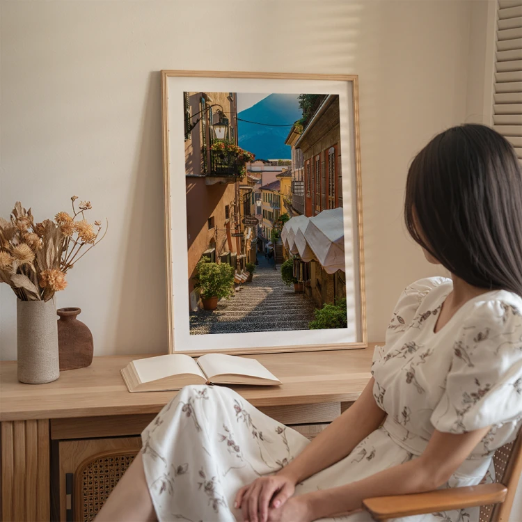 plakat bellagio uliczka nad jeziorem como z białym obramowaniem na biurku